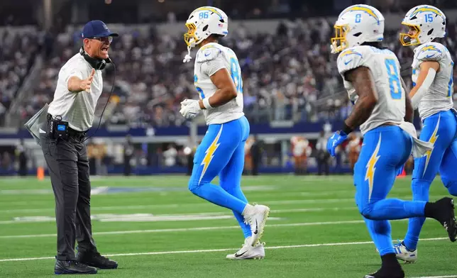 Los Angeles Chargers head coach Jim Harbaugh celebrates after a touchdown by Los Angeles Chargers running back Omarion Hampton (8) during the second half of an NFL football game against the Dallas Cowboys, Sunday, Dec. 21, 2025, in Arlington, Texas. (AP Photo/Julio Cortez)