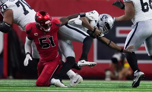 Las Vegas Raiders quarterback Geno Smith, right, scrambles away from Houston Texans defensive end Will Anderson Jr. (51) during the second half of an NFL football game, Sunday, Dec. 21, 2025, in Houston. (AP Photo/Ashley Landis)