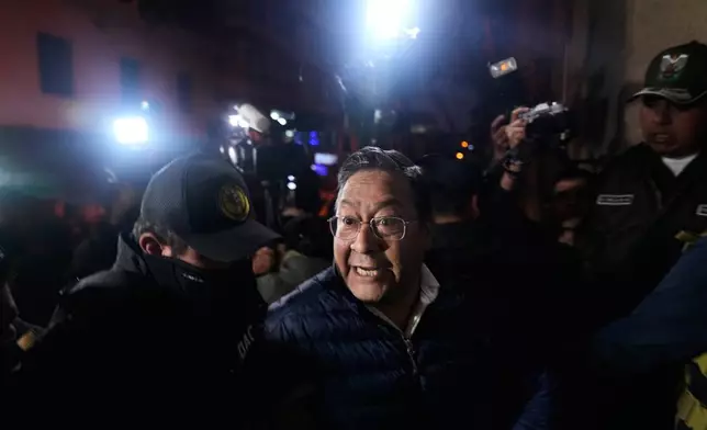 Police officers escort former President Luis Arce to San Pedro Prison after his arrest as part of a corruption investigation in La Paz, Bolivia, Friday, Dec. 12, 2025. (AP Photo/Juan Karita)