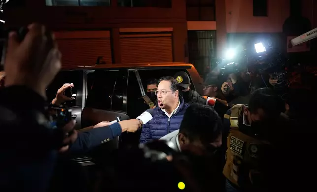 Former President Luis Arce comments to the press as he is escorted to San Pedro Prison after his arrest as part of a corruption investigation in La Paz, Bolivia, Friday, Dec. 12, 2025. (AP Photo/Juan Karita)