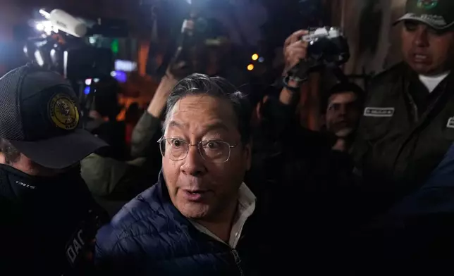 Police officers escort former President Luis Arce to San Pedro Prison after his arrest as part of a corruption investigation in La Paz, Bolivia, Friday, Dec. 12, 2025. (AP Photo/Juan Karita)