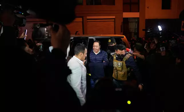 Police officers escort former President Luis Arce to San Pedro Prison after his arrest as part of a corruption investigation in La Paz, Bolivia, Friday, Dec. 12, 2025. (AP Photo/Juan Karita)