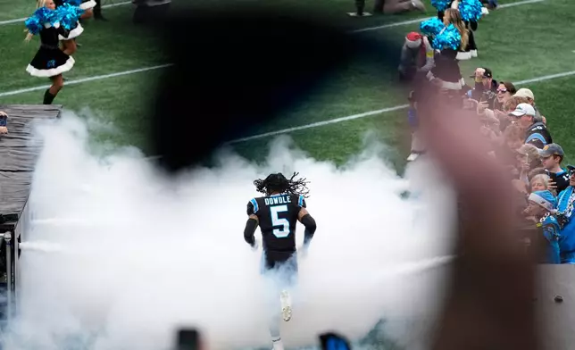 Carolina Panthers running back Rico Dowdle runs onto the field before an NFL football game against the Tampa Bay Buccaneers, Sunday, Dec. 21, 2025, in Charlotte, N.C. (AP Photo/Erik Verduzco)
