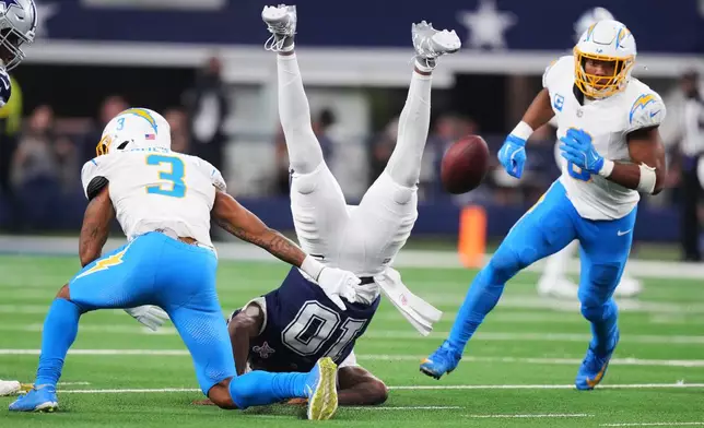 Dallas Cowboys quarterback Joe Milton (10) fumbles as he is tackled by Los Angeles Chargers free safety Derwin James (3) during the second half of an NFL football game Sunday, Dec. 21, 2025, in Arlington, Texas. (AP Photo/Julio Cortez)