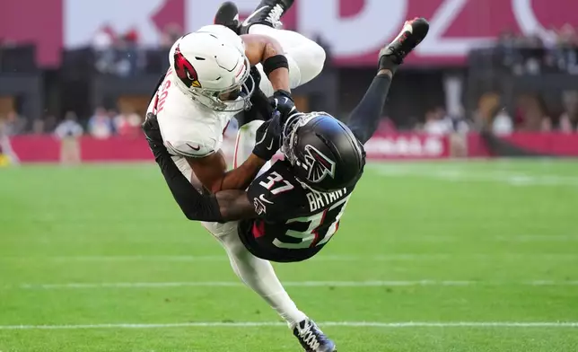 Arizona Cardinals wide receiver Michael Wilson (14) scores a touchdown against Atlanta Falcons cornerback Cobee Bryant (37) during the first half of an NFL football game, Sunday, Dec. 21, 2025, in Glendale, Ariz. (AP Photo/Rick Scuteri)
