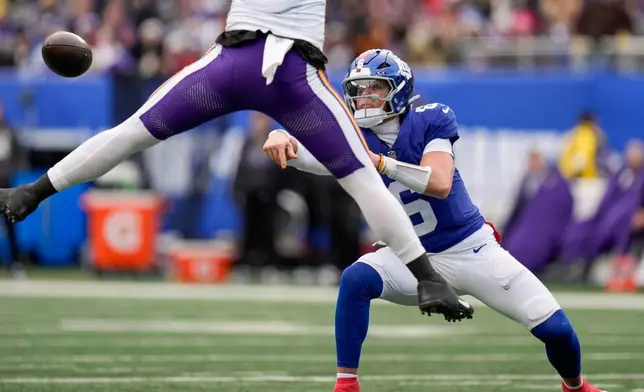 New York Giants quarterback Jaxson Dart (6) passes under pressure against the Minnesota Vikings during the second quarter of an NFL football game, Sunday, Dec. 21, 2025, in East Rutherford, N.J. (AP Photo/Seth Wenig)