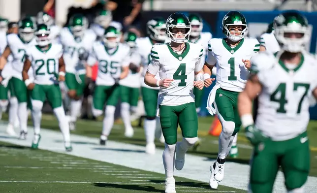 New York Jets quarterback Brady Cook (4) runs on field before the first half of an NFL football game against the Jacksonville Jaguars, Sunday, Dec. 14, 2025, in Jacksonville, Fla. (AP Photo/John Raoux)