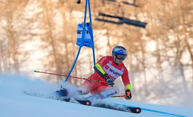 Switzerland's Marco Odermatt speeds down the course during an alpine ski, men's World Cup giant slalom event, in Val d'Isere, France, Saturday Dec. 13, 2025. (AP Photo/Giovanni Auletta)