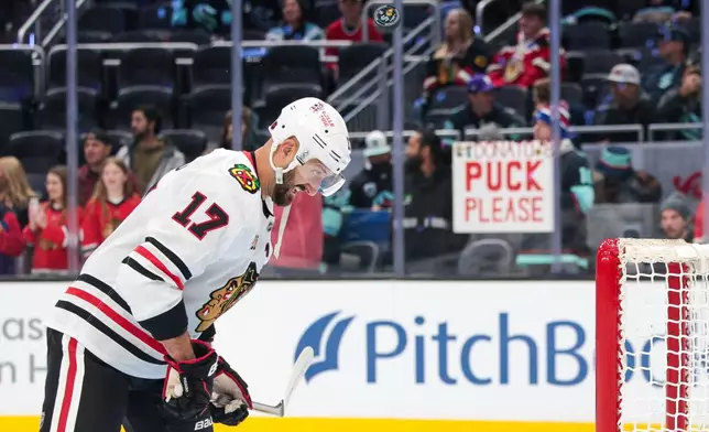 FILE - Chicago Blackhawks left wing Nick Foligno (17) head butts a puck into the net during warmups before an NHL hockey game against the Seattle KrakenMonday, Nov. 3, 2025, in Seattle. (AP Photo/Jason Redmond, File)