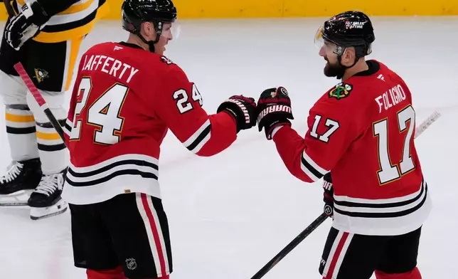 Chicago Blackhawks left wing Nick Foligno, right, celebrates with center Sam Lafferty after scoring a goal during the second period of an NHL hockey game against the Pittsburgh Penguins in Chicago, Sunday, Dec. 28, 2025. (AP Photo/Nam Y. Huh)