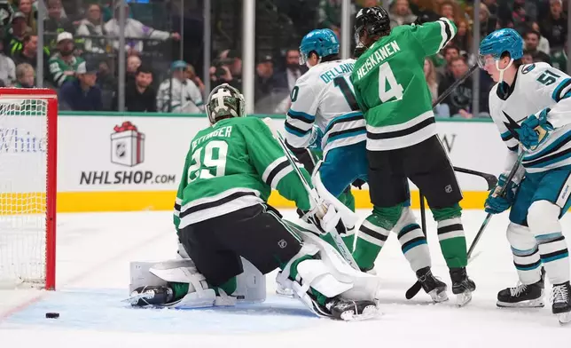 San Jose Sharks right wing Collin Graf (51) scores against Dallas Stars goaltender Jake Oettinger (29) and defenseman Miro Heiskanen (4) during the second period of an NHL hockey game Friday, Dec. 5, 2025, in Dallas. (AP Photo/LM Otero)