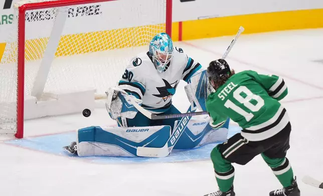 San Jose Sharks goaltender Yaroslav Askarov (30) defends against Dallas Stars center Sam Steel (18) during the third period of an NHL hockey game Friday, Dec. 5, 2025, in Dallas. (AP Photo/LM Otero)