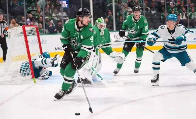 Dallas Stars defenseman Miro Heiskanen (4) takes control of the puck as San Jose Sharks center Will Smith (2) skates up during the second period of an NHL hockey game Friday, Dec. 5, 2025, in Dallas. (AP Photo/LM Otero)