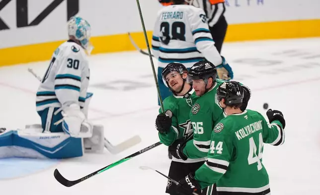 Dallas Stars right wing Mikko Rantanen (96) celebrates his goal with teammates Vladislav Kolyachonok (44) and Sam Steel (18) as San Jose Sharks goaltender Yaroslav Askarov (30) sits nearby during the third period of an NHL hockey game Friday, Dec. 5, 2025, in Dallas. (AP Photo/LM Otero)