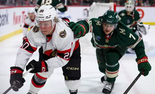 Ottawa Senators left wing Fabian Zetterlund, left, and Minnesota Wild defenseman Brock Faber (7) compete for the puck during the third period of an NHL hockey game Saturday, Dec. 13, 2025, in St. Paul, Minn. (AP Photo/Matt Krohn)