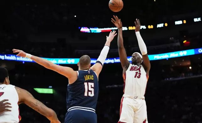Miami Heat center Bam Adebayo (13) shoots over Denver Nuggets center Nikola Jokic (15) during the first half of an NBA basketball game, Monday, Dec. 29, 2025, in Miami. (AP Photo/Lynne Sladky)