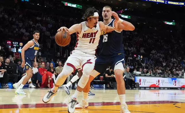 Miami Heat forward Jaime Jaquez Jr. (11) drives to the basket as Denver Nuggets center Nikola Jokic (15) defends during the first half of an NBA basketball game, Monday, Dec. 29, 2025, in Miami. (AP Photo/Lynne Sladky)