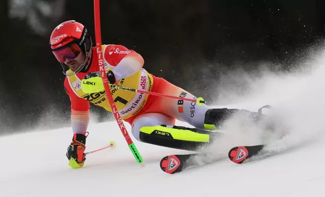Switzerland's Loic Meillard speeds down the course during an alpine ski, men's World Cup slalom, in Alta Badia, Italy, Monday, Dec. 22, 2025. (AP Photo/Alessandro Trovati)