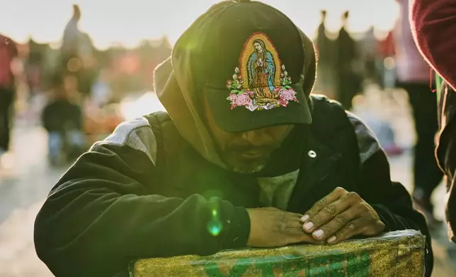A man prays outside the Basilica of Our Lady of Guadalupe in Mexico City, on her feast day, Friday, Dec. 12, 2025. (AP Photo/Claudia Rosel)
