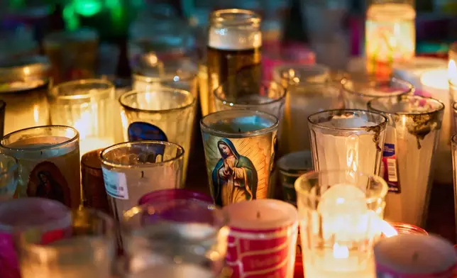 Candles with the image of the Virgin of Guadalupe sit inside the Basilica of Guadalupe in Mexico City, Thursday, Dec. 11, 2025, the day before her feast day. (AP Photo/Claudia Rosel)