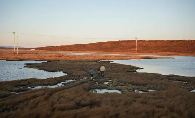 Roswell Schaeffer, an Inupiaq hunter and fisher, takes his great-grandson James Schaeffer, 7, and James' cousin Charles Gallahorn, 10, hunting in Kotzebue, Alaska, Friday, Sept. 26, 2025. (AP Photo/Annika Hammerschlag)