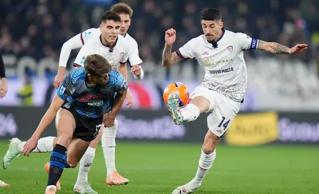 Atalanta's Charles De Ketelaere, front left, and Cagliari's Alessandro Deiola, right, challenge for the ball during the Serie A soccer match between Atalanta Bergamo and Cagliari Calcio in Bergamo, Italy, Saturday Dec. 13, 2025. (Spada/LaPresse via AP)