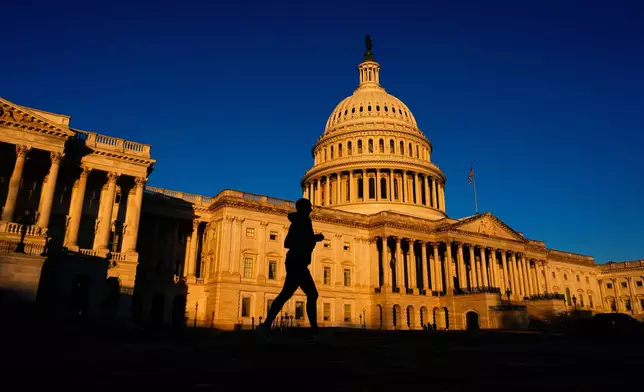 A runner jogs past the U.S. Capitol shortly after sunrise, Tuesday, Dec. 16, 2025, in Washington. (AP Photo/Julia Demaree Nikhinson)