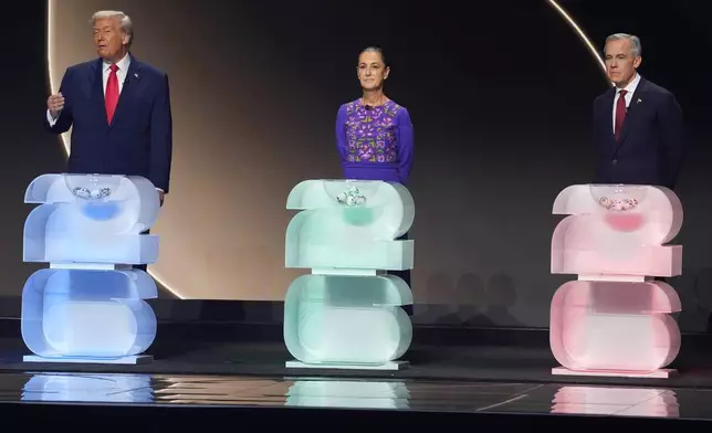President Donald Trump, left, speaks as Mexican President Claudia Sheinbaum, center, and Canadian Prime Minister Mark Carney, right, stand on stage during the draw for the 2026 soccer World Cup at the Kennedy Center in Washington, Friday, Dec. 5, 2025. (AP Photo/Evan Vucci)