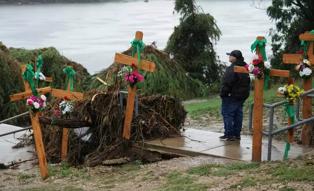 FILE - Rain falls as Irene Valdez visits a make-shift memorial for flood victims along the Guadalupe River, Sunday, July 13, 2025, in Kerrville, Texas. (AP Photo/Eric Gay, File)