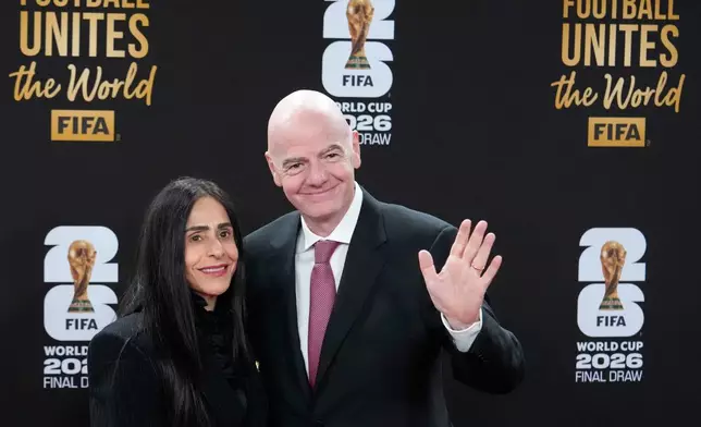 FIFA President Gianni Infantino and his wife Leena Al Ashqar pose for a photo as they arrive for a welcome reception ahead of the draw for 2026 soccer World Cup at the Kennedy Center in Washington, Thursday, Dec. 4, 2025. (AP Photo/Chris Carlson)