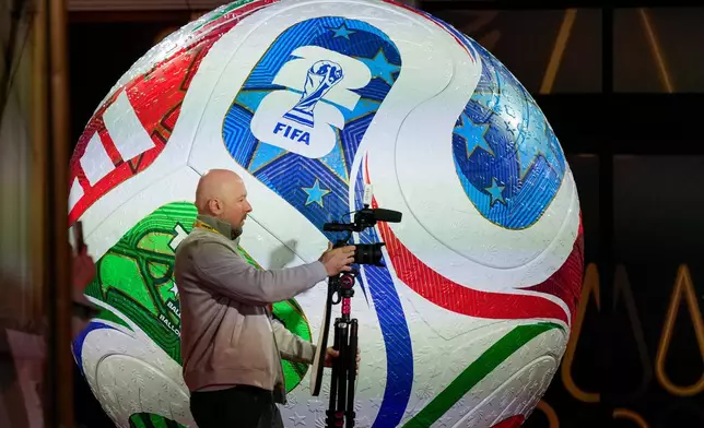 A member of the media works prior to the final draw for the 2026 soccer World Cup at the Kennedy Center in Washington, Thursday, Dec. 4, 2025. (AP Photo/Chris Carlson)