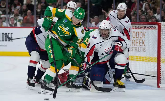 Minnesota Wild center Ben Jones (39) and Washington Capitals left wing Alex Ovechkin (8) battle for the puck during the first period of an NHL hockey game, Tuesday, Dec. 16, 2025, in St. Paul, Minn. (AP Photo/Abbie Parr)