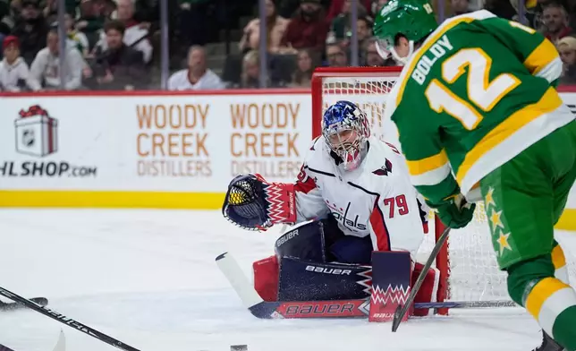 Washington Capitals goaltender Charlie Lindgren (79) defends against a shot by Minnesota Wild left wing Matt Boldy (12) during the first period of an NHL hockey game, Tuesday, Dec. 16, 2025, in St. Paul, Minn. (AP Photo/Abbie Parr)