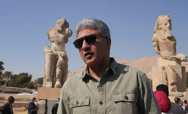 Minister of Tourism and Antiquities Sherif Fathy speaks in front of the two giant reassembled alabaster statues of Pharoah Amenhotep III, in the southern city of Luxor, Egypt, Sunday, Dec. 14, 2025. (AP Photo/Amr Nabil)