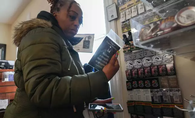 Keisha Burse looks at items for sale at Martin Luther King Jr. National Historical Park, Tuesday, Dec. 9, 2025, in Atlanta. (AP Photo/Megan Varner)