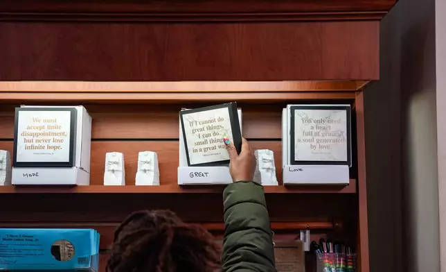 Keisha Burse looks at items for sale at Martin Luther King Jr. National Historical Park, Tuesday, Dec. 9, 2025, in Atlanta. (AP Photo/Megan Varner)