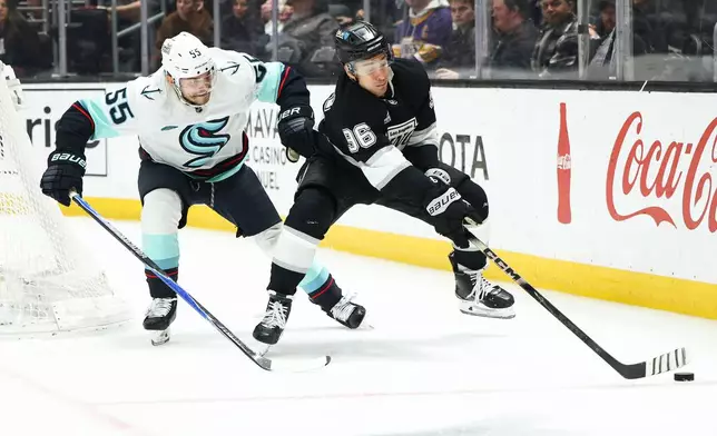 Los Angeles Kings left wing Andrei Kuzmenko (96) battles for the puck against Seattle Kraken defenseman Ryan Lindgren (55) during the second period of an NHL hockey game, Tuesday, Dec. 23, 2025, in Los Angeles. (AP Photo/Jessie Alcheh)