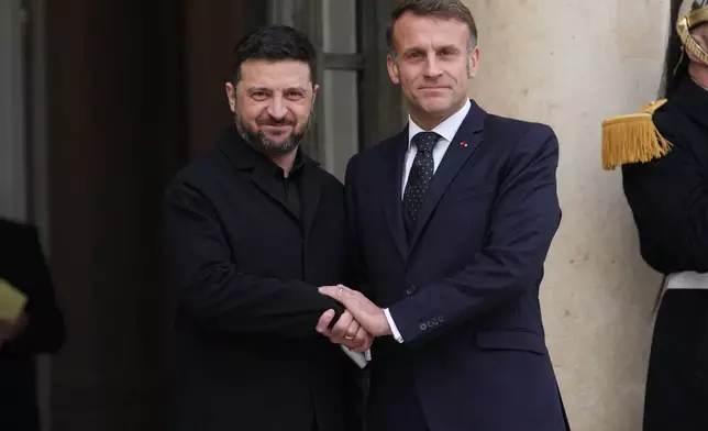 French President Emmanuel Macron, right, welcomes Ukrainian President Volodymyr Zelenskyy, Monday, Dec. 1, 2025 before a meeting at the Elysee Palace in Paris. (AP Photo/Christophe Ena)