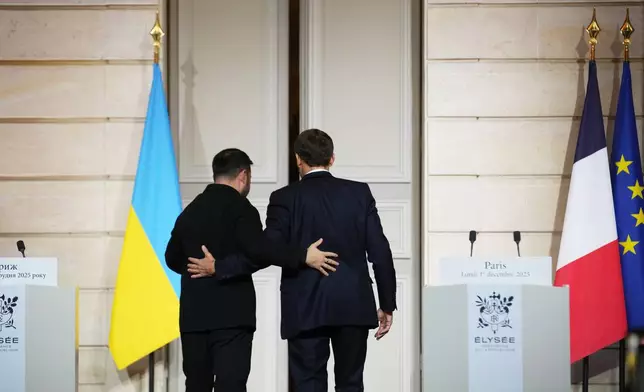 French President Emmanuel Macron, right, and Ukrainian President Volodymyr Zelenskyy leave after a joint press conference at the Elysee Palace in Paris, Monday, Dec 1, 2025. (AP Photo/Christophe Ena, Pool)