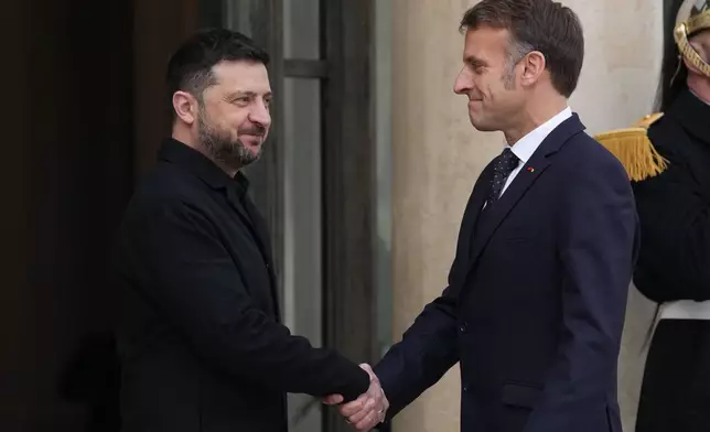 French President Emmanuel Macron, right, welcomes Ukrainian President Volodymyr Zelenskyy, Monday, Dec. 1, 2025 before a meeting at the Elysee Palace in Paris. (AP Photo/Christophe Ena)