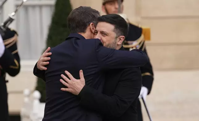 French President Emmanuel Macron, left, welcomes Ukrainian President Volodymyr Zelenskyy, Monday, Dec. 1, 2025 before a meeting at the Elysee Palace in Paris. (AP Photo/Christophe Ena)