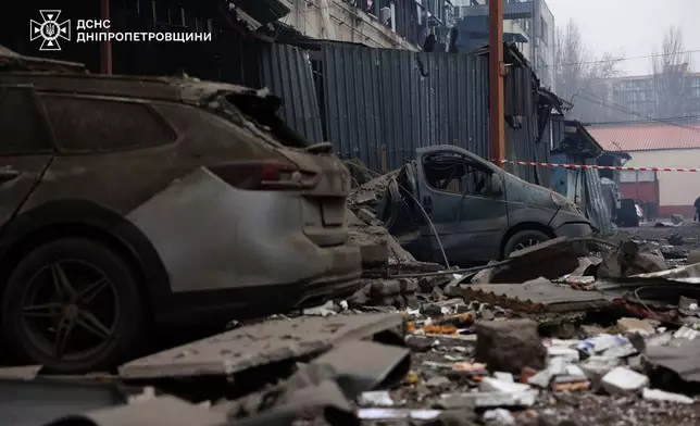 This photo provided by the Ukrainian Emergency Service, shows damaged cars and debris after a Russian missiles attack in Dnipro, Ukraine, Monday, Dec. 1, 2025. (Ukrainian Emergency Service via AP)
