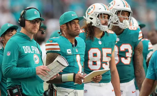 Miami Dolphins quarterback Tua Tagovailoa (1) watches from the sidelines during the second half of an NFL football game against the Cincinnati Bengals, Sunday, Dec. 21, 2025, in Miami Gardens, Fla. (AP Photo/Rebecca Blackwell)