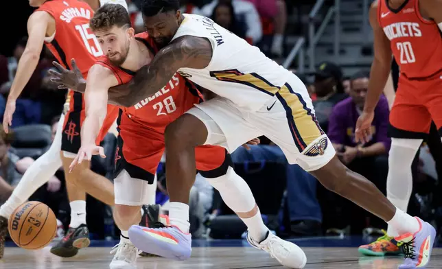 Houston Rockets center Alperen Sengun (28) and New Orleans Pelicans forward Zion Williamson, center right, battle for the ball during the first half of an NBA basketball game in New Orleans, Thursday, Dec. 18, 2025. (AP Photo/Matthew Hinton)