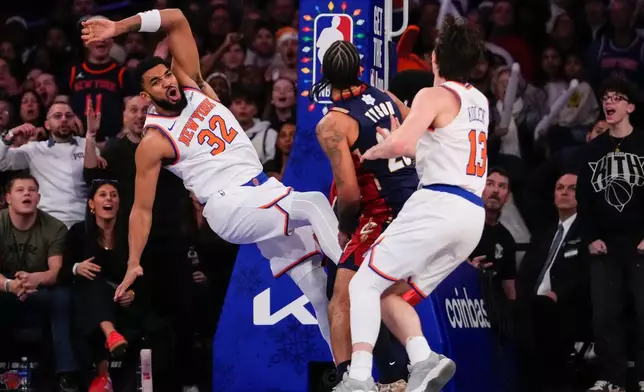 New York Knicks center Karl-Anthony Towns (32) falls after shooting during the first half of an NBA basketball game against Cleveland Cavaliers, Thursday, Dec. 25, 2025, in New York. (AP Photo/Yuki Iwamura)