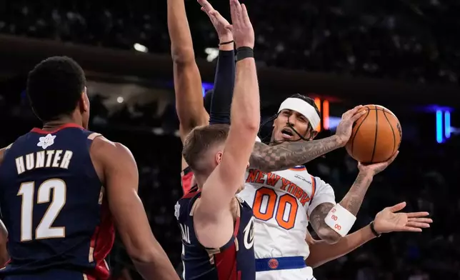 New York Knicks guard Jordan Clarkson (00) is blocked by Cleveland Cavaliers guard Sam Merrill (5) during the second half of an NBA basketball game, Thursday, Dec. 25, 2025, in New York. (AP Photo/Yuki Iwamura)