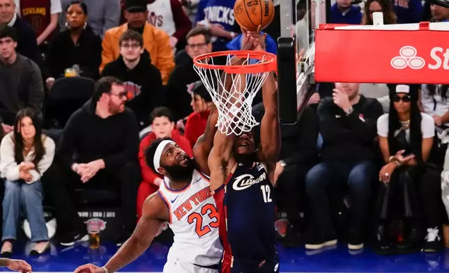 New York Knicks center Mitchell Robinson (23) blocks Cleveland Cavaliers forward De'Andre Hunter (12) during the first half of an NBA basketball game, Thursday, Dec. 25, 2025, in New York. (AP Photo/Yuki Iwamura)
