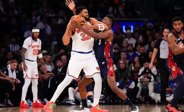 New York Knicks center Karl-Anthony Towns (32) fights for control of the ball with Cleveland Cavaliers center Thomas Bryant (3) during the first half of an NBA basketball game, Thursday, Dec. 25, 2025, in New York. (AP Photo/Yuki Iwamura)