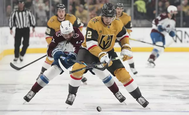 Colorado Avalanche right wing Valeri Nichushkin (13) and Vegas Golden Knights defenseman Zach Whitecloud (2) vie for the puck during the first period of an NHL hockey game Saturday, Dec. 27, 2025, in Las Vegas. (AP Photo/Candice Ward)
