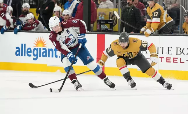 Colorado Avalanche defenseman Cale Makar (8) skates with the puck against Vegas Golden Knights left wing Ivan Barbashev (49) during the second period of an NHL hockey game, Saturday, Dec. 27, 2025, in Las Vegas. (AP Photo/Candice Ward)